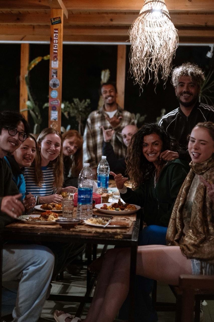 Hicham with guests around the dinner table at the surf house